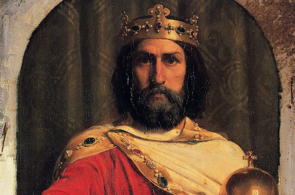 Carlos Magno, imperador. A imagem mostra seu busto com uma roupa vermelha e amarela, coroa e o símbolo da igreja.