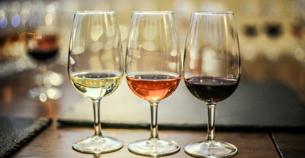 3 taças de vinho dispostas uma ao lado da outra com vinho branco, rosé e tinto