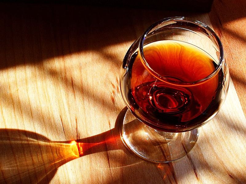 Taça de vinho fortificado em cima de uma mesa de madeira. 