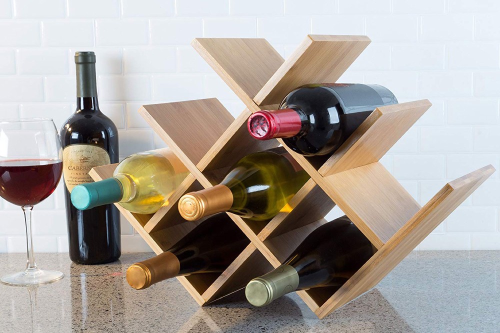 Taça e garrafa de vinho ao lado de rack de vinhos feito de madeira