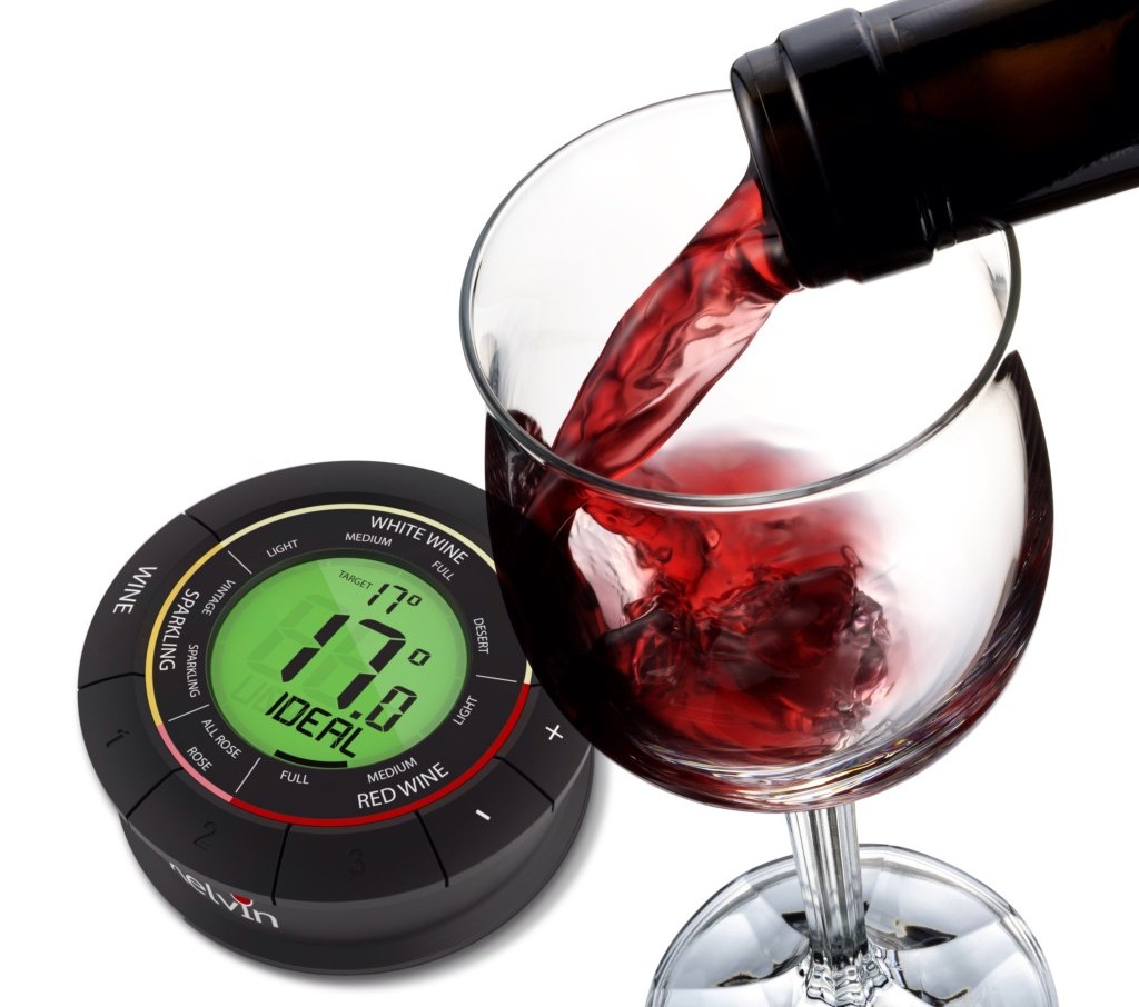 Detalhe de um vinho tinto sendo colocado em uma taça ao lado de um termômetro de vinho ilustrando trecho sobre qual a temperatura ideal do vinho no inverno